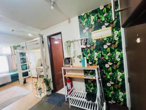 a room with a green wall with flowers on it at Casa Tagpuan in Manhattan ParkWay in Manila +19 photos