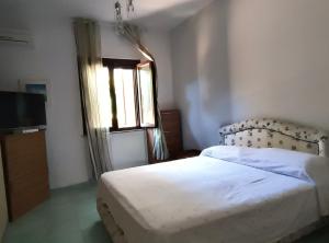 a bedroom with a bed and a window and a television at Villa Angelina in Gaeta +2 photos