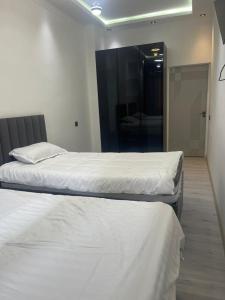 two twin beds in a room with a mirror at Palace Apartament in Dushanbe
