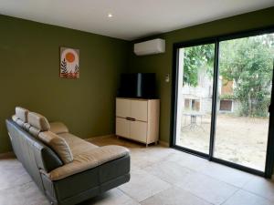 a living room with a couch and a television at Casa Alta in Zonza