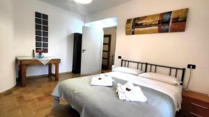 una camera da letto con un letto con asciugamani sopra di 4 minuti da San Carlo Acutis, 8 ospiti, 140 mq, ALL'OMBRA DI SANTA CHIARA, Piano Terra 2 Ingressi 3 Camere 2 Bagni, Idromassaggio, Perfetto - La nostra Forza è PRESENZA LIVE 24-7, MyAssisiSuite, più di un semplice Appartamento - MÓWIMY PO POLSKU ad Assisi