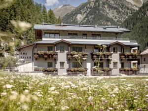 een gebouw met bloemen voor een berg bij The River by Regina in Sölden