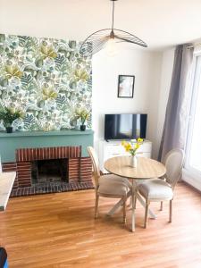a living room with a table and chairs and a fireplace at 35 m2 charmant plus 30 M2 de terrasse Accès jardin SPA in Boulogne-sur-Mer