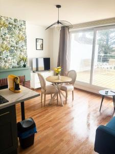 a living room with a table and chairs and a patio at 35 m2 charmant plus 30 M2 de terrasse Accès jardin SPA in Boulogne-sur-Mer
