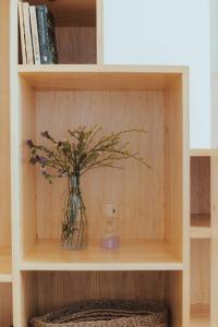 a vase of flowers sitting on a shelf at Alojamentos Plansel - No Coração das Vinhas do Alentejo in Montemor-o-Novo