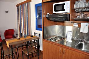 a small kitchen with a table and a microwave at Ellibay in Livadia