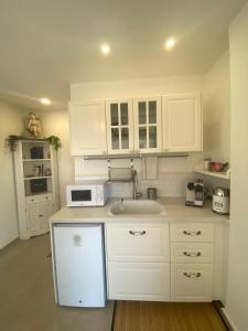 a white kitchen with a sink and a microwave at סוד הנחלים in Sede Neẖemya +13 photos