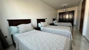 a room with three beds and a room with at Duplex imiouaddar in Imi Ouaddar
