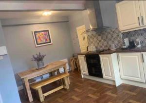 a kitchen with white cabinets and a table in it at Enniscrone House in Enniscrone