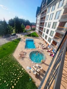 un hotel con piscina al lado de un edificio en Residence Hill Lux, en Kopaonik 123 fotos más