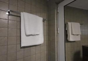 a bathroom with white towels hanging on a shower at Captain's View in Dobra Voda