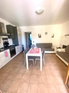 a kitchen and living room with a white table and chairs at Wendy House RESIDENCE CORTE COLLINA in Castion Veronese