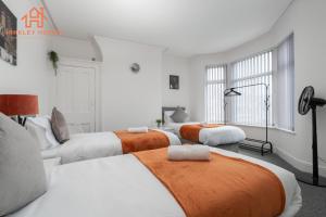 a bedroom with four beds with orange and white at 9 Guests, 4 Bedrooms, Modern Comfort in Bootle in Litherland