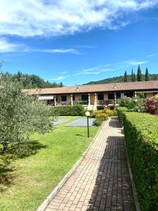 a building with a brick walkway in front of a yard at Wendy House RESIDENCE CORTE COLLINA in Castion Veronese