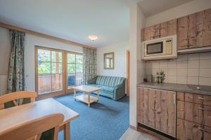 a kitchen and living room with a couch and a microwave at Ferienhaus Hotel Rösslwirt in Kirchberg in Tirol