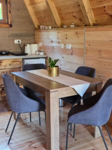 - une table en bois dans une cuisine avec des chaises bleues dans l'établissement Cottage forest hill 2, à Žabljak