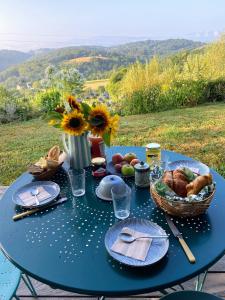 a blue table with food and a vase of flowers at Poulou Pyrénées in Gelos