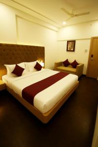 ein Schlafzimmer mit einem großen Bett und einer Couch in der Unterkunft FabHotel New Rajdoot - Bhopal railway station platform no 6 in Bhopal