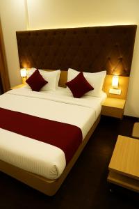ボーパールにあるHotel Partinidhi Staysのベッドルーム1室(大型ベッド1台、赤と白の枕付)