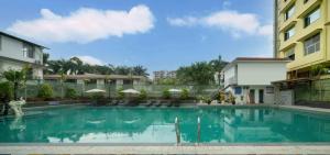 a large swimming pool in front of a building at Home2 Suite by Hilton Xishuangbanna Jinghong in Jinghong