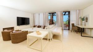 Una sala de estar con un sofá y un televisor. en Aparthotel Novo Resort, en Chiclana de la Frontera