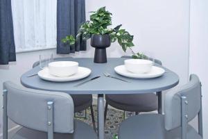 a blue table with plates and bowls and chairs at Stylish 3bedroom near Stoke-on-Trent hospital in Stoke on Trent