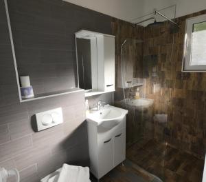 a bathroom with a sink and a mirror and a shower at Captain's View in Dobra Voda