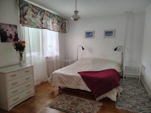 a bedroom with a bed and a dresser and a window at Hus mellan Jädraås Kungsberget in Jädraås