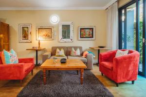 a living room with two red chairs and a coffee table at 17onWellington Apartments in George