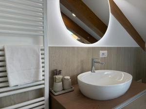 Un baño con un lavabo blanco y un espejo. en Palazzo Machiavelli Trieste, en Trieste 249 fotos más