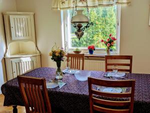a dining room with a purple table with chairs and a window at Hus mellan Jädraås Kungsberget in Jädraås