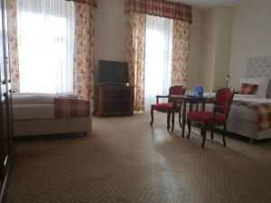 a hotel room with a bed and a table and chairs at Pałac Brunów - Wellness & SPA in Lwówek Śląski