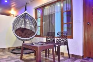 een kamer met twee stoelen en een hangstoel met een laptop bij The Jungle Track Kasauli in Kasauli +40 foto's