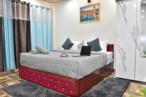 a bedroom with a bed with a laptop on it at Inder Homestay Kasuali in Kasauli