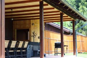 a wooden pavilion with chairs and a grill at Varsag Resort in Vărşag