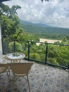 a balcony with a table and chairs and a view at Hotel Ganga Pearl in Rishīkesh