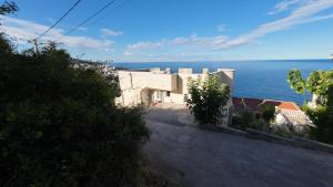 a view of a building with the ocean in the background at Captain's View in Dobra Voda