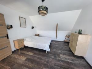 een slaapkamer met een wit bed en een houten vloer bij La marine D'opale in Ambleteuse
