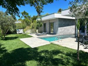 a backyard with a swimming pool and a house at Hilltop Villa in Shetaj