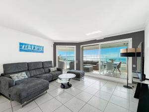 un soggiorno con un divano e un tavolo di Grand bleu Front de Mer Magnifique 3 Pièces garage a Antibes