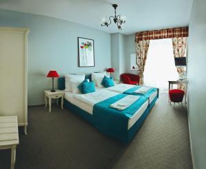 a blue bedroom with a large bed and a window at Pałac Brunów - Wellness & SPA in Lwówek Śląski