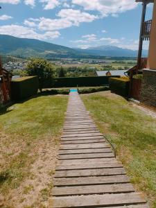 a wooden pathway on the side of a house at Vistas excepcionales, jardín con piscina, muy acogedor in Saillagouse