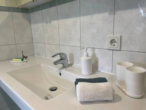 a bathroom sink with a faucet and two cups at Neue Ferienwohnung mit Terrasse in Guteborn +18 photos