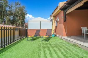 two chairs sitting on the grass in a backyard at Bungalow Albatros Relajante BBQ en Maspalomas in Playa del Ingles