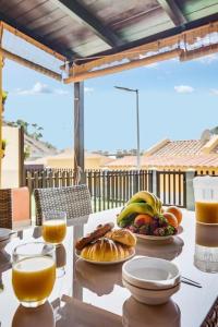 a table with plates of food and orange juice at Bungalow Albatros Relajante BBQ en Maspalomas in Playa del Ingles