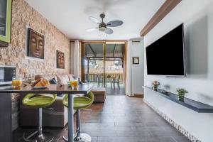 a living room with a table and a television at Bungalow Albatros Relajante BBQ en Maspalomas in Playa del Ingles