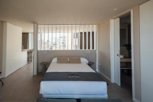 a bedroom with a bed and a large window at BN SUITES San Francisco in Alicante