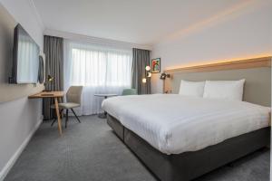 a hotel room with a large bed and a desk at Holiday Inn Bristol Filton by IHG in Bristol