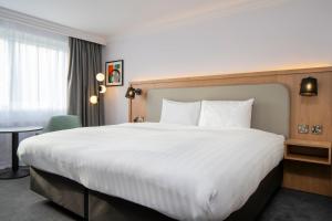 a hotel room with a large bed and a table at Holiday Inn Bristol Filton by IHG in Bristol