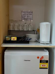 a refrigerator with a shelf on top of it at Country Roads Motor Inn in Narrandera